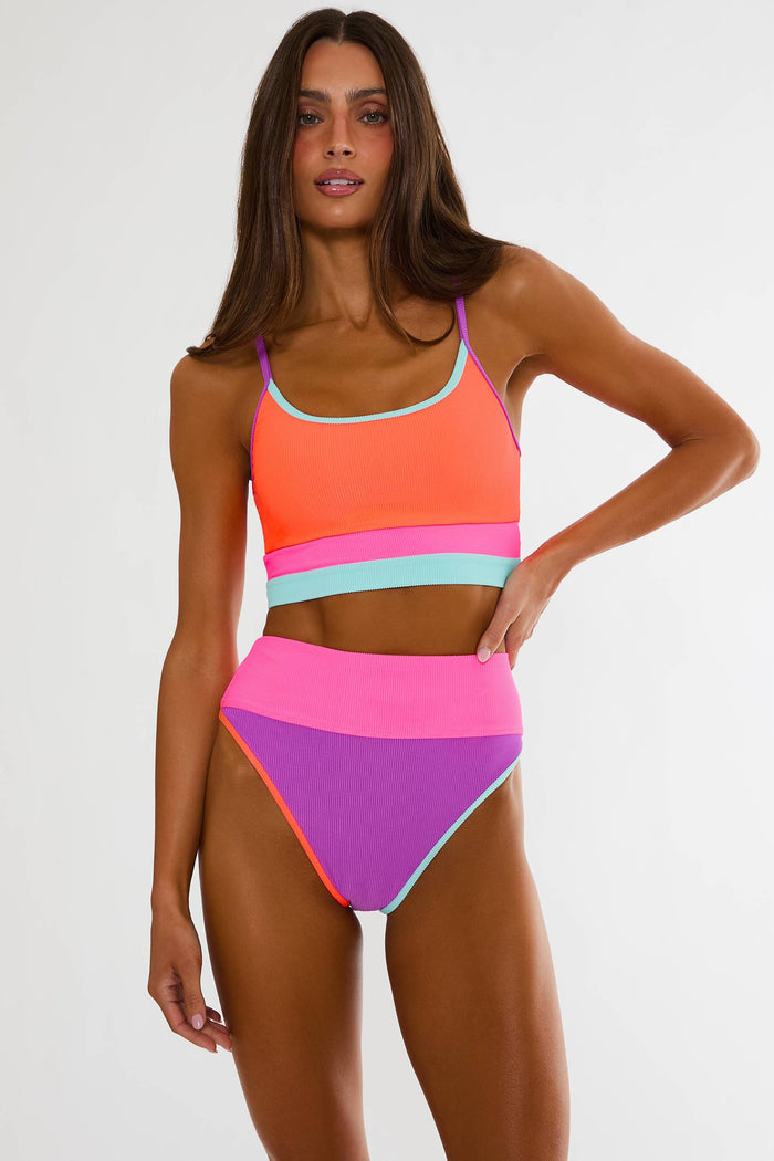 Woman wearing a colorful bikini set on a white background