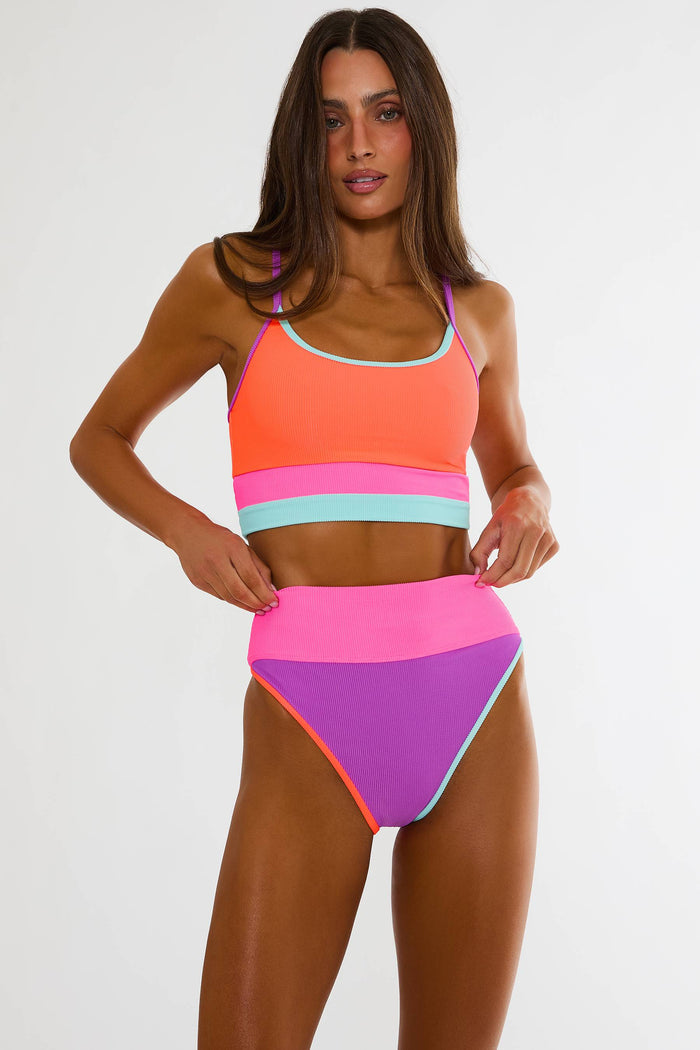 Woman wearing a colorful two-piece swimsuit on a white background