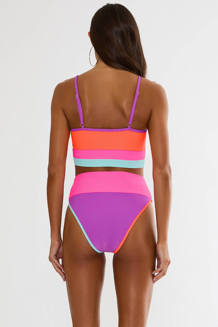Woman wearing a colorful bikini set on a white background
