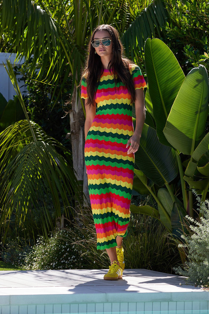 A model wearing a colorful striped maxi dress with cap sleeves.