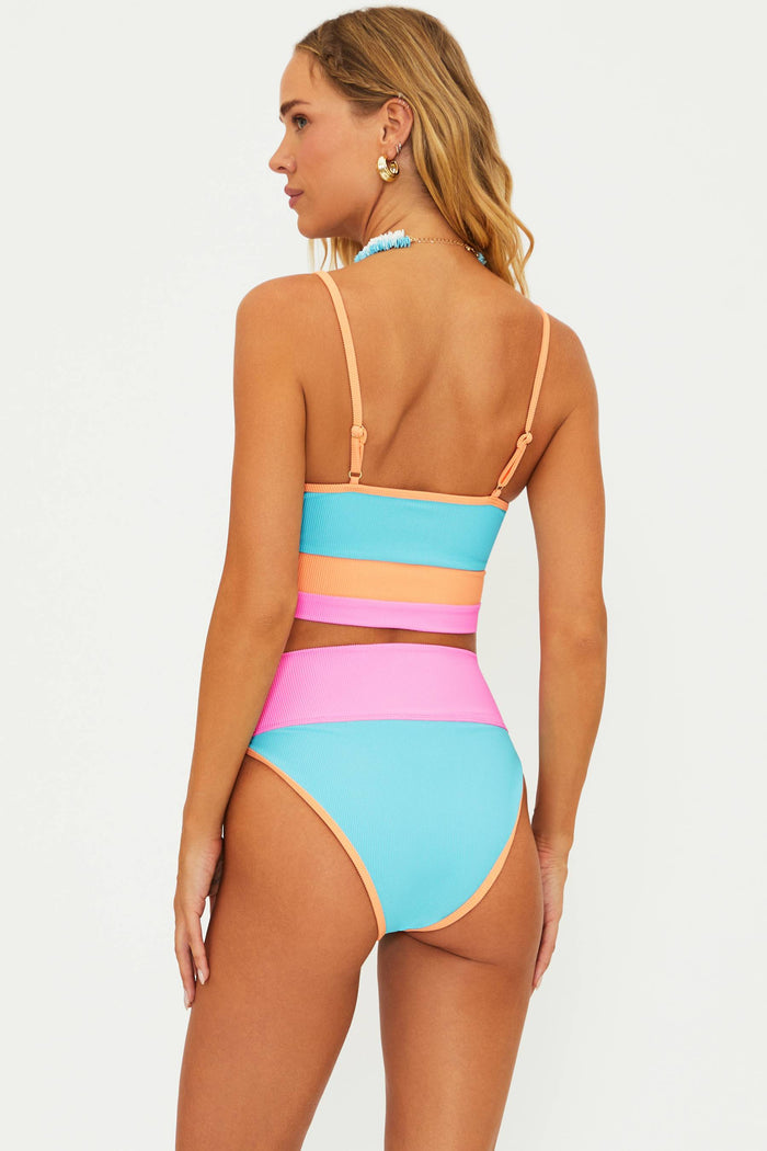A high-waisted, moderate coverage swim bottom with crush colorblock design, featuring ribbed fabric in blue, pink, and orange.