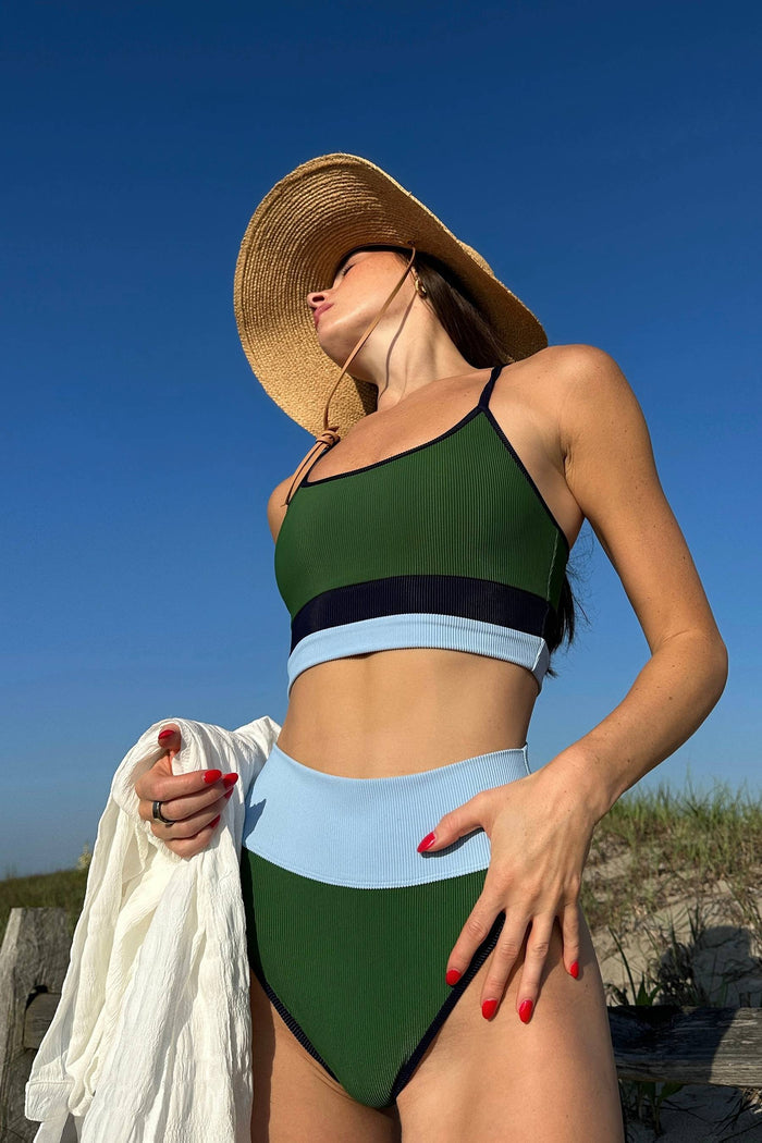 Woman in a green bikini and straw hat on a beach
