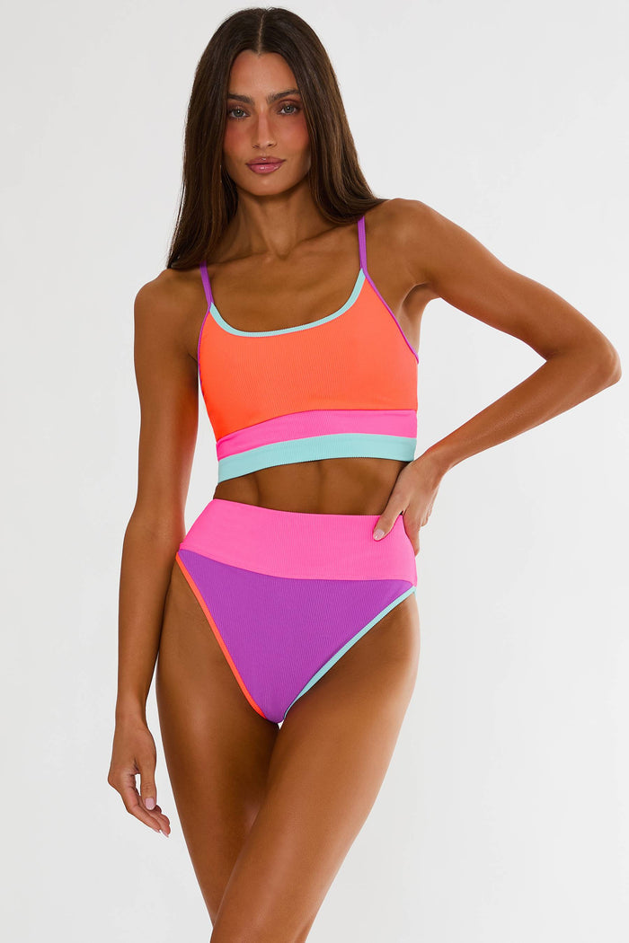 Woman wearing a colorful striped swimsuit on a white background