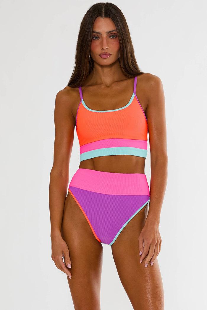 Woman wearing a colorful two-piece swimsuit on a white background