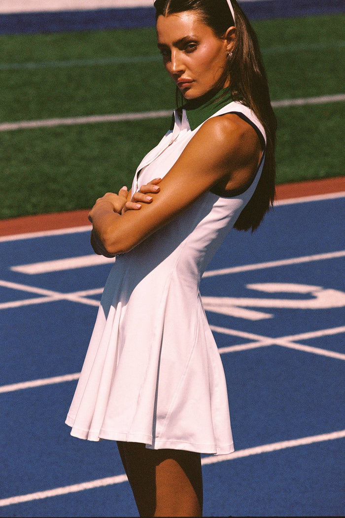 Woman in a white dress standing on a tennis court