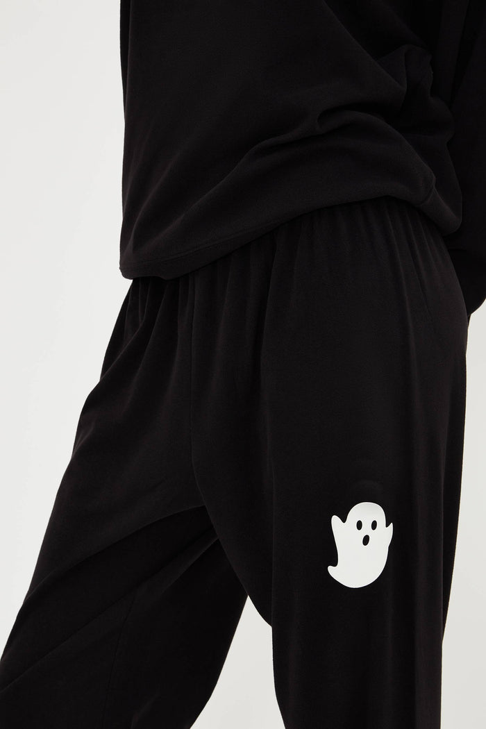 Black pants with a white ghost design on a light gray background