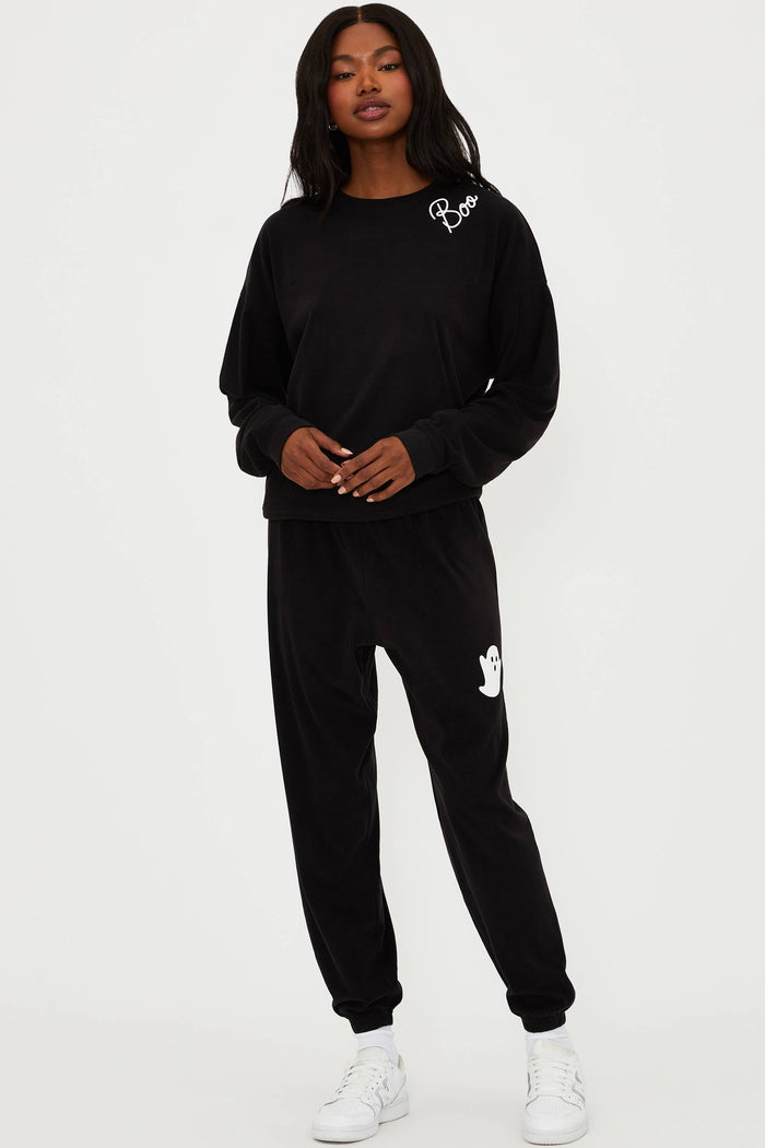 Person wearing a black tracksuit with white text on a white background