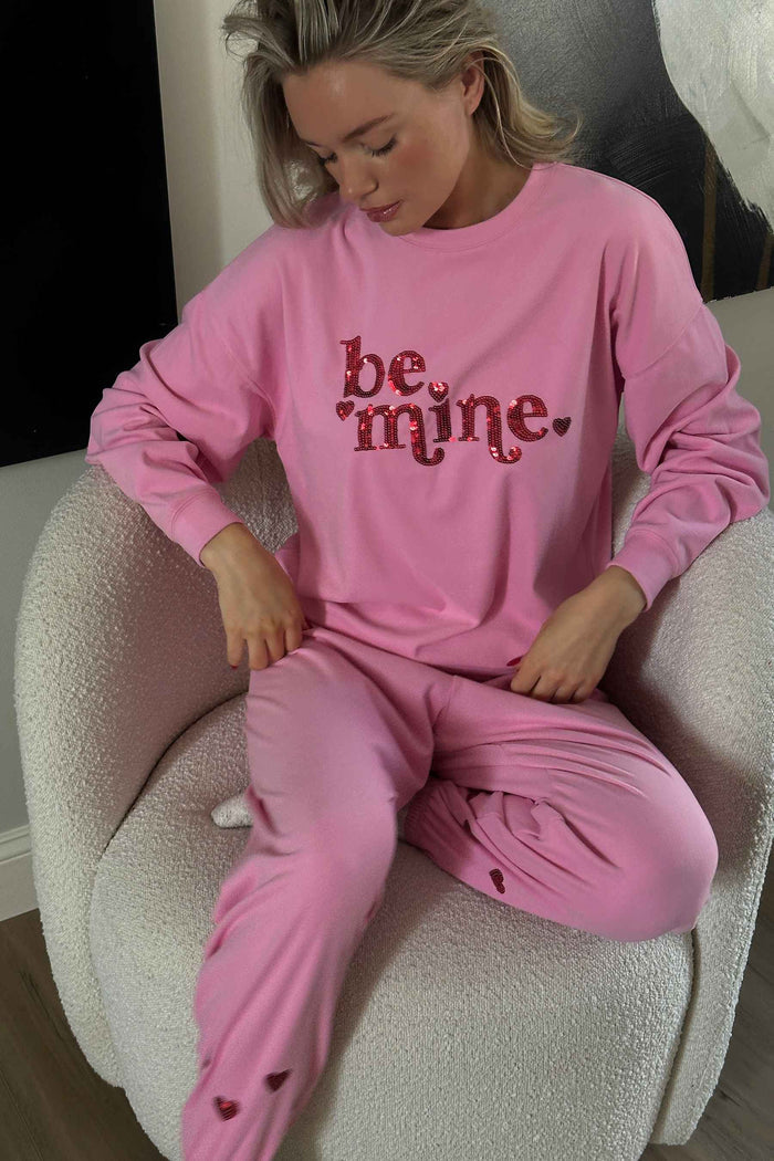 Pink sweatshirt with "be mine" in red sequin