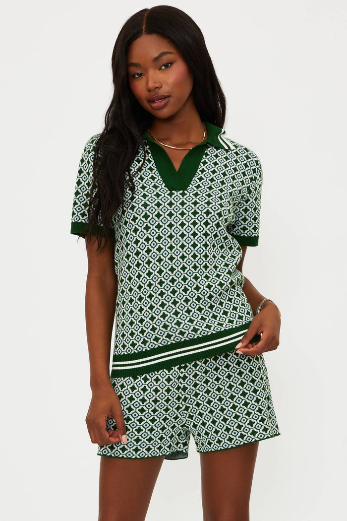 Woman wearing a green and white patterned outfit on a plain background