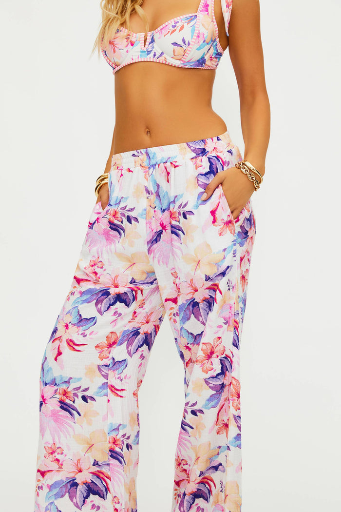 Person wearing a colorful floral outfit on a white background