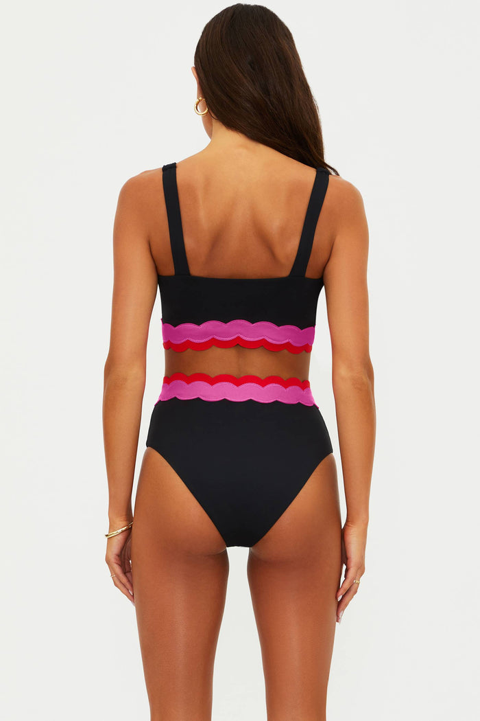 Black swimsuit with colorful ruffled top on a white background