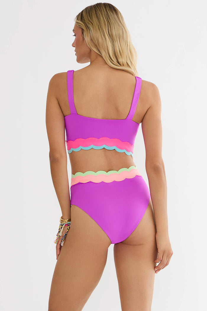 Woman wearing a colorful bikini set on a white background