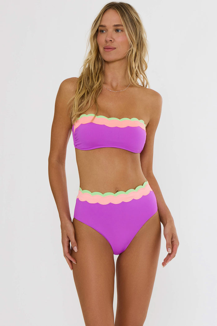 Woman wearing a colorful bikini with a plain background
