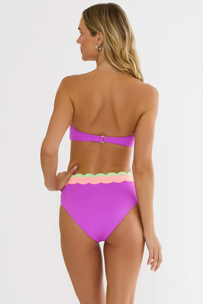 Woman wearing a colorful bikini with a white background