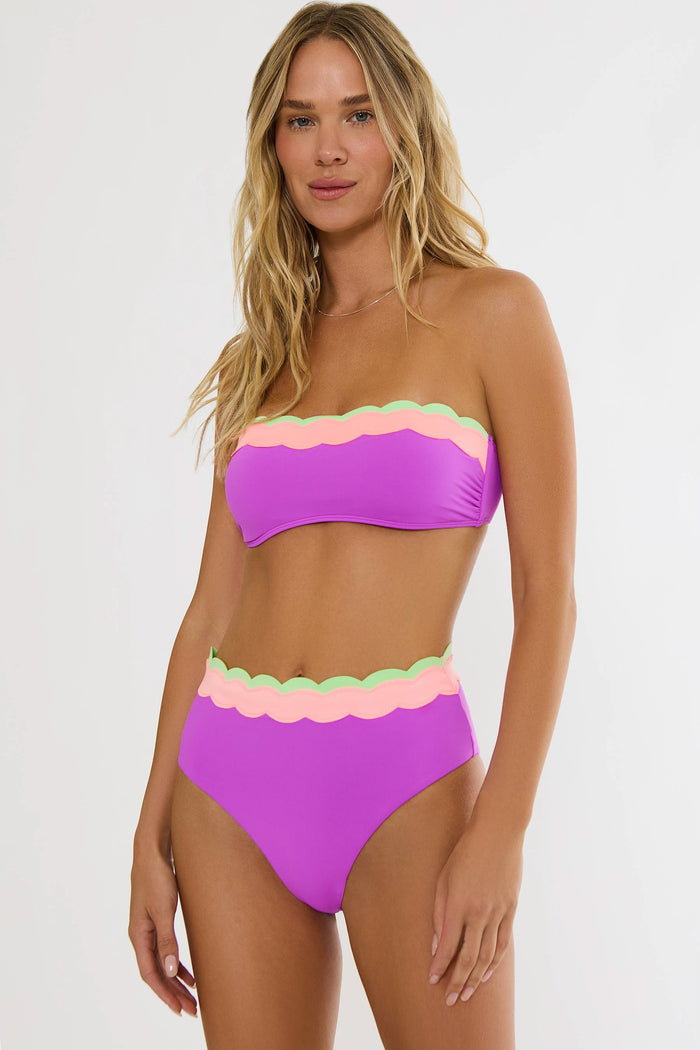 Woman wearing a colorful bikini with a white background