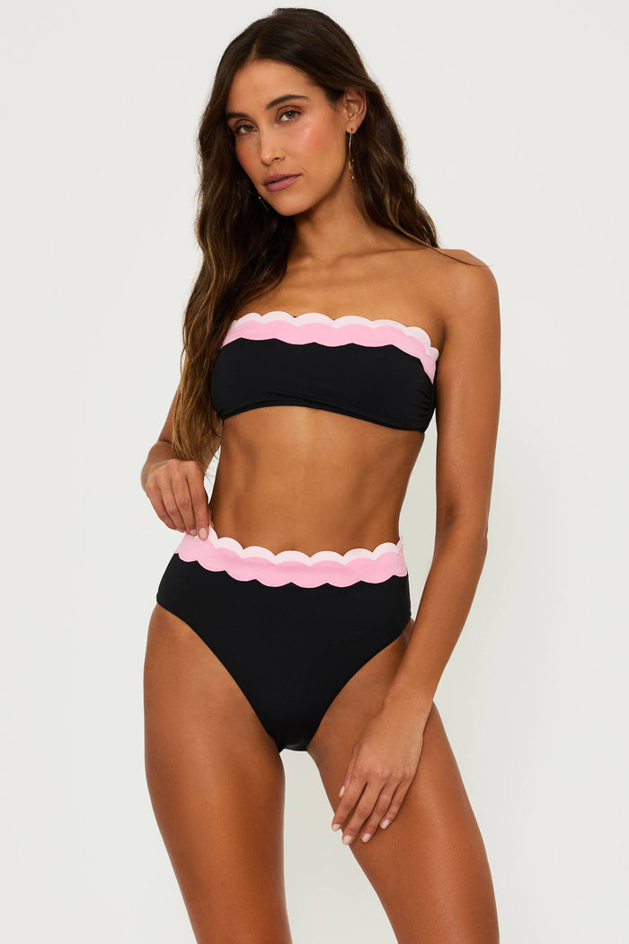 black bralette style swim top with pink contrast wavy trim and a black high waist bottom with pink wavy trim and the top of the waist band