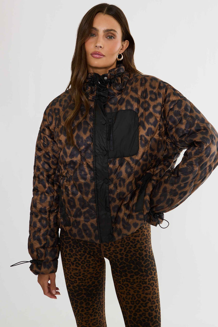 Woman wearing brown and black leopard puffer jacket.