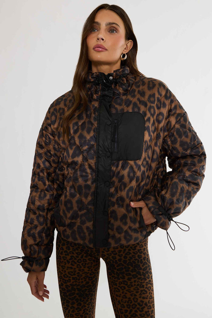 Woman wearing brown and black leopard puffer jacket.