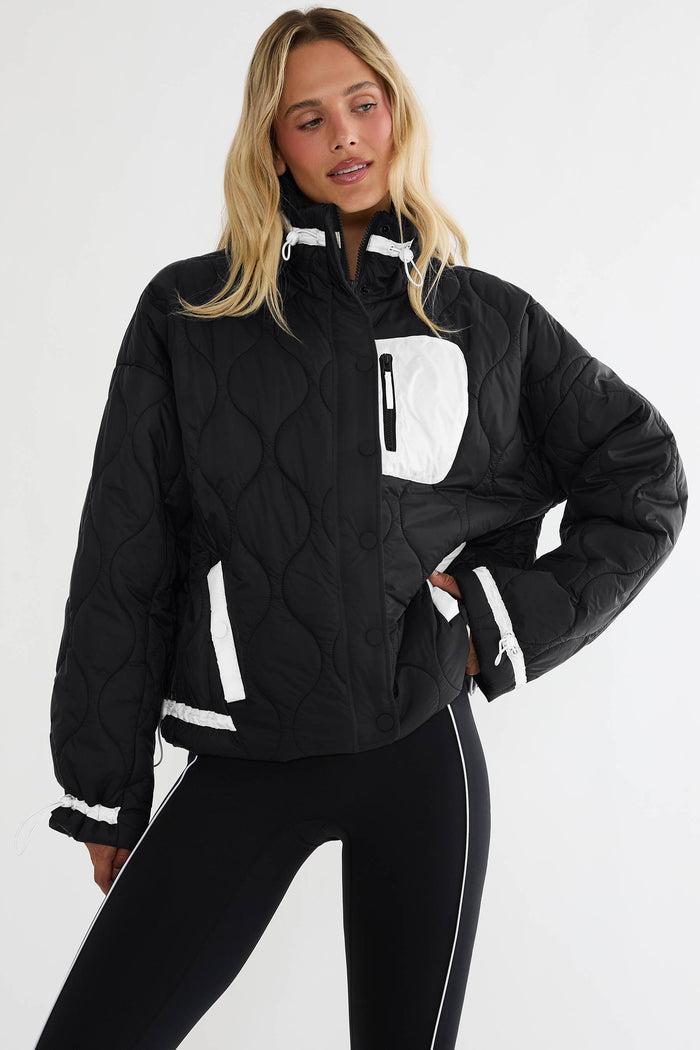 Black puffer zip up with beige detailing.
