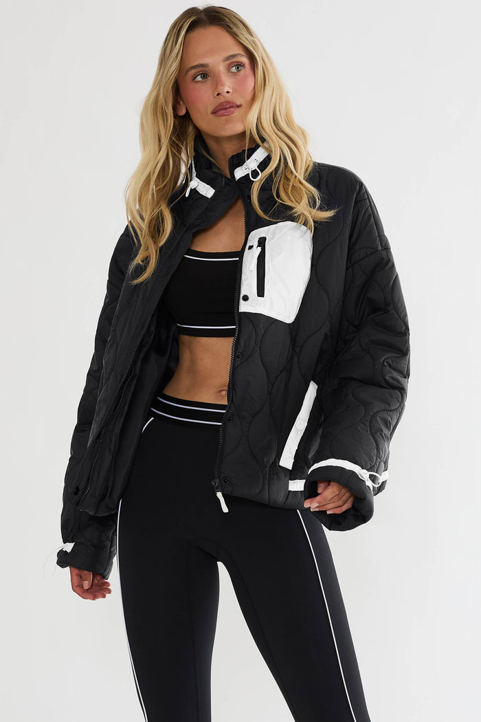Black puffer zip up with beige detailing.