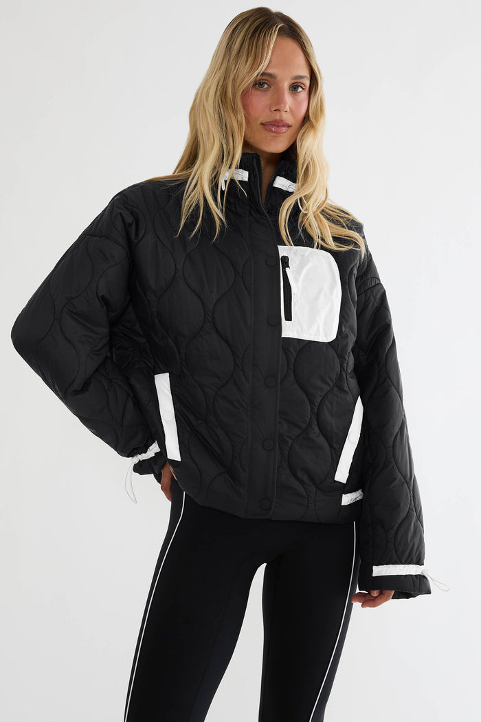 Black puffer zip up with beige detailing.