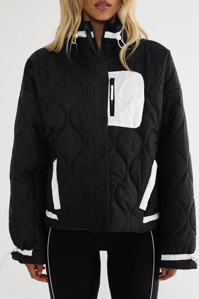 Black puffer zip up with beige detailing.