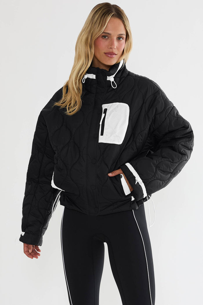 Black puffer zip up with beige detailing.