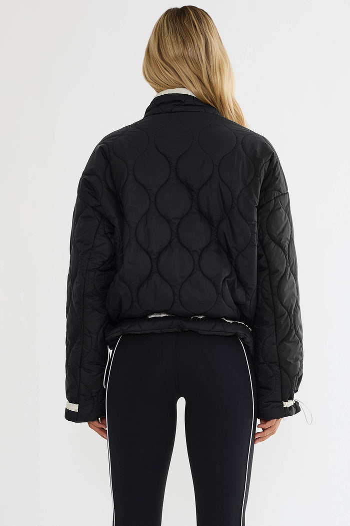 Black puffer zip up with beige detailing.