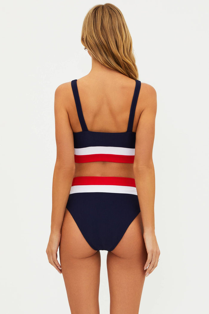 A model wearing a high waist silhouette swim bottom with a red, white, and blue colorblock design.