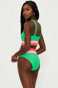 A model is wearing a high-rise green swim bottom with colorblock stripes in pink and white, part of the 'Heidi' collection.