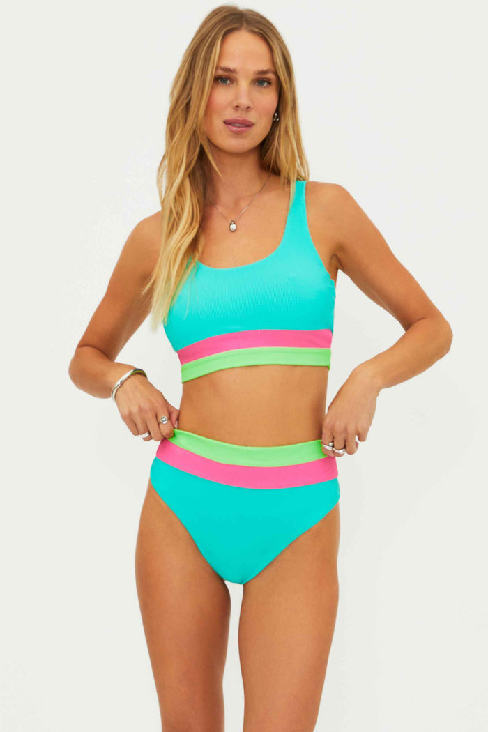 Woman wearing a colorful two-piece swimsuit on a white background