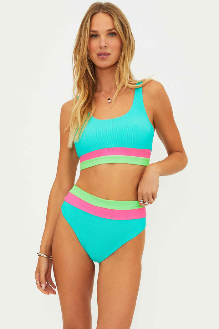 Woman wearing a colorful two-piece swimsuit on a white background