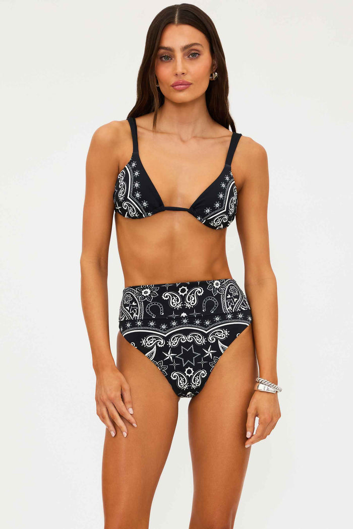 Woman wearing a black and white patterned bikini on a white background