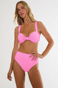 Woman wearing a pink bikini set on a white background