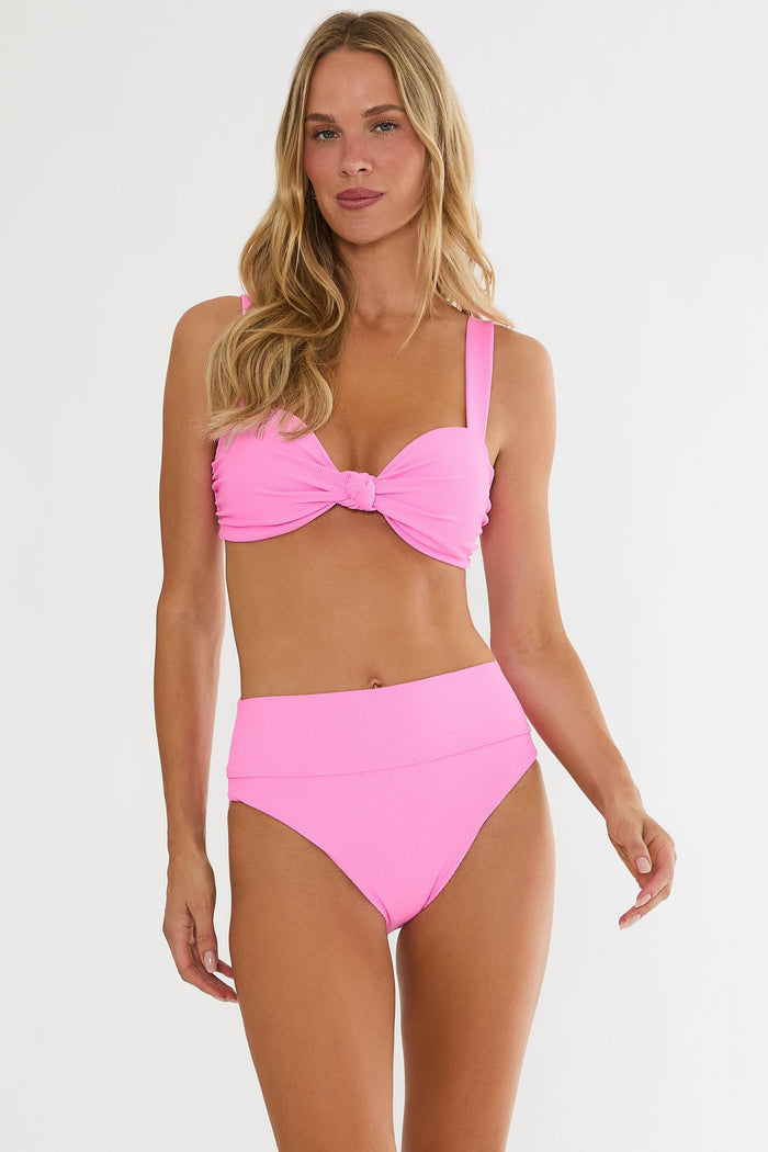 Woman wearing a pink bikini set on a white background