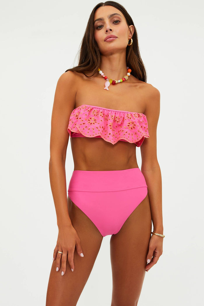 Woman wearing a pink bikini with a white background