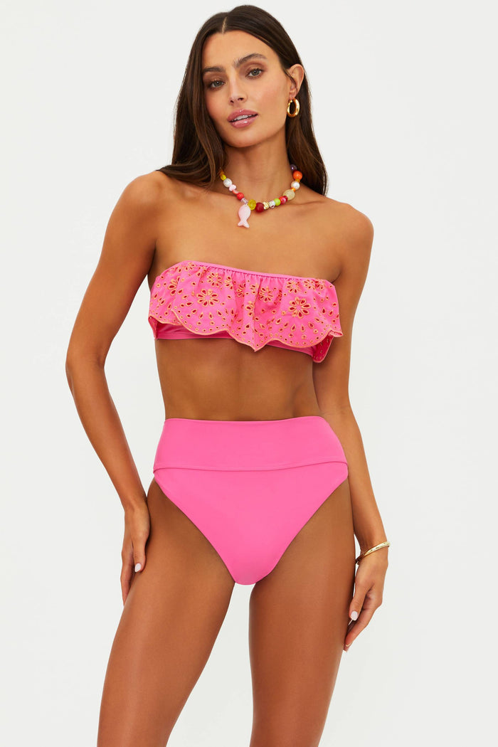 Woman wearing a pink bikini set with a white background