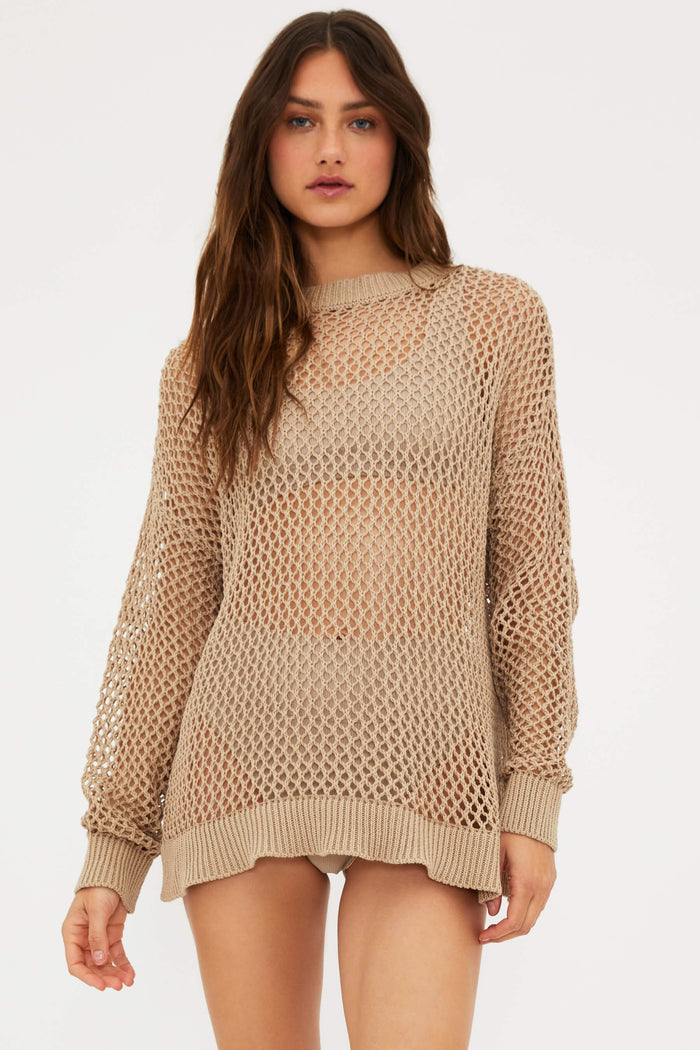 A female model wearing a tan mesh long sleeve crew neck sweater.