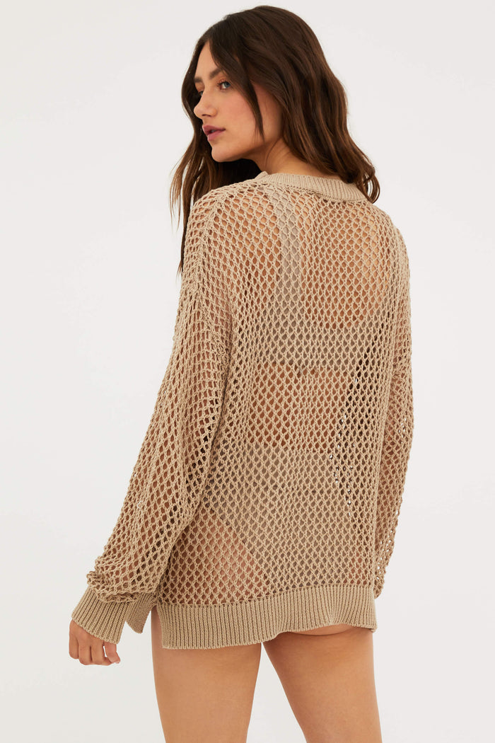 A female model wearing a tan mesh long sleeve crew neck sweater.