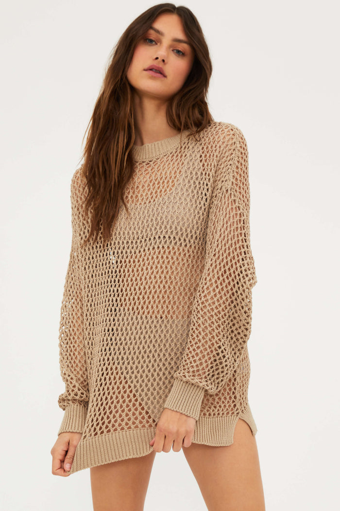 A female model wearing a tan mesh long sleeve crew neck sweater.