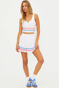 Woman wearing a white outfit with colorful trim on a white background