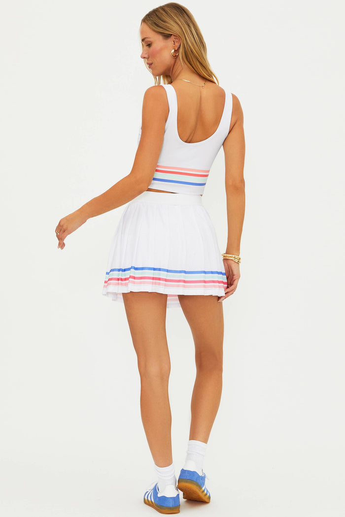 Woman wearing a white dress with colorful stripes on a white background