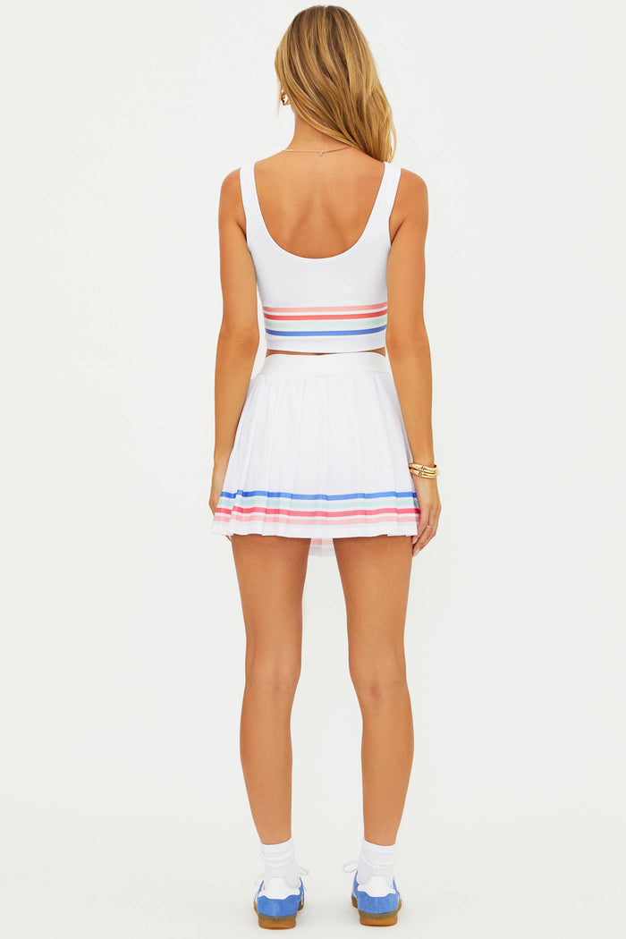 Woman wearing a white dress with colorful stripes on a white background