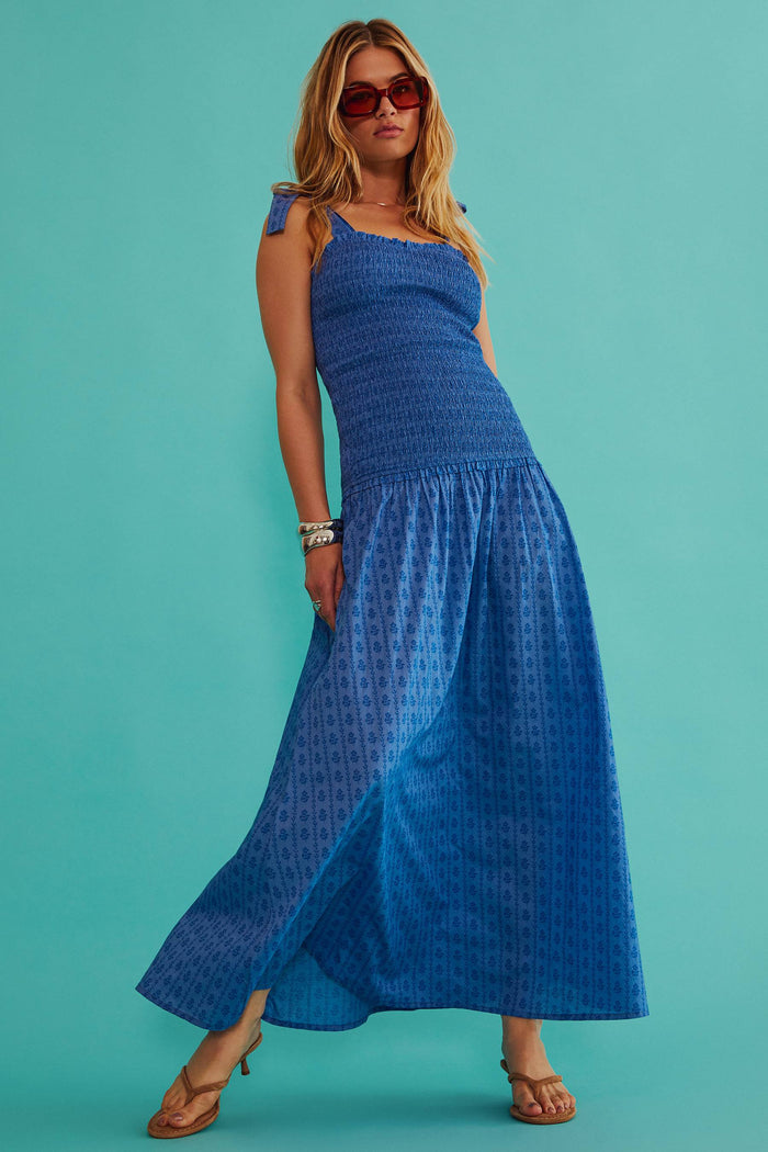 Woman wearing a blue dress against a teal background