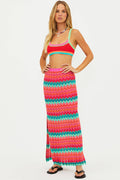 Woman wearing a colorful striped top and skirt on a white background