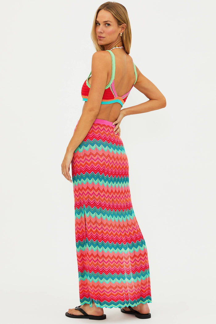 Woman wearing a colorful zigzag patterned dress on a white background
