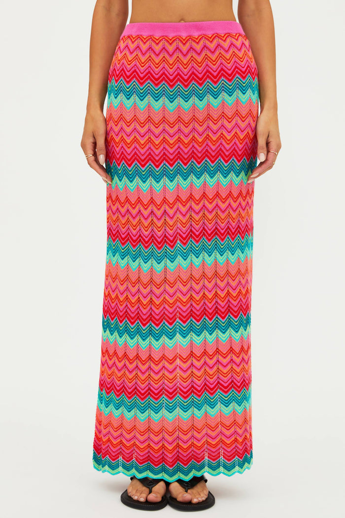 Multicolored zigzag patterned skirt worn by a person on a white background