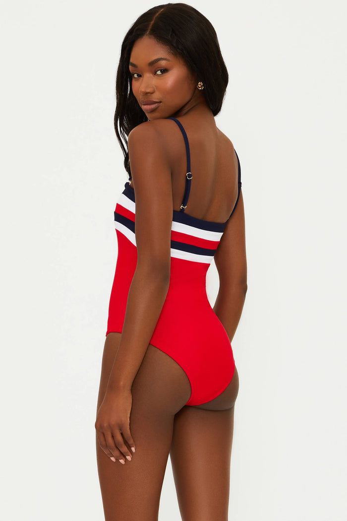 A model wearing a red, white, and blue one-piece swimsuit with a colorblock design.