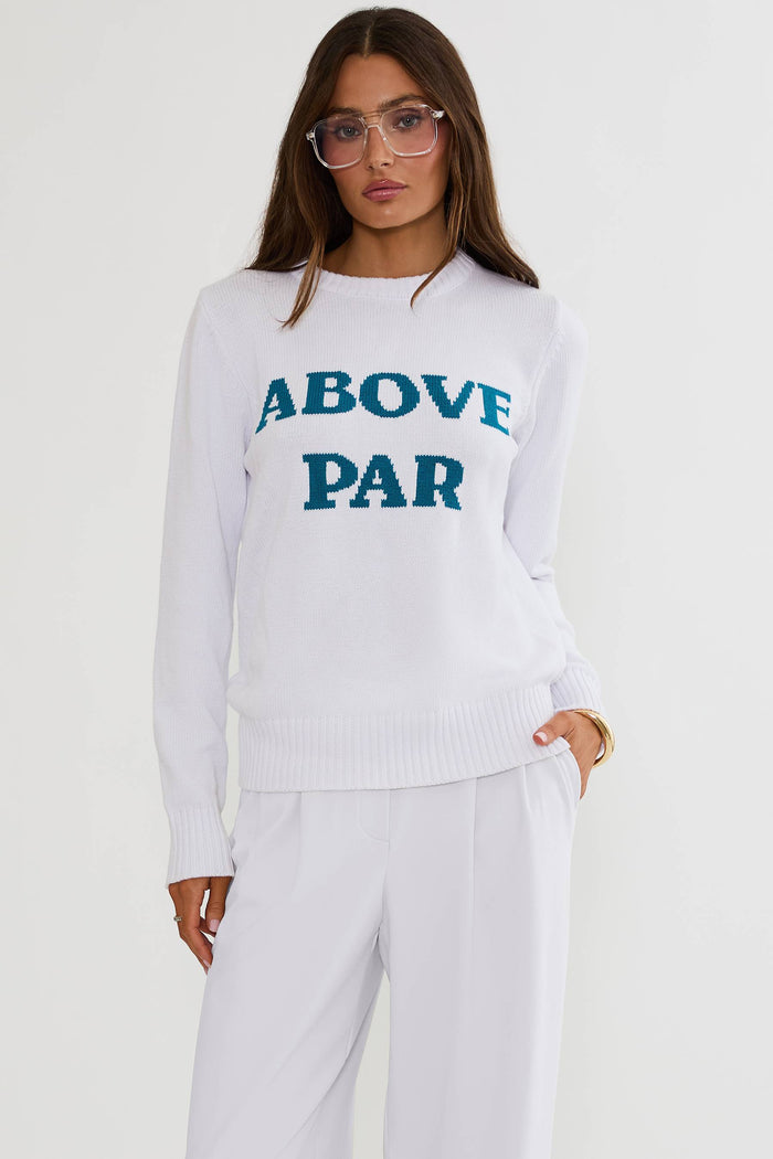 Person wearing a white sweater with 'ABOVE PAR' text on a plain background