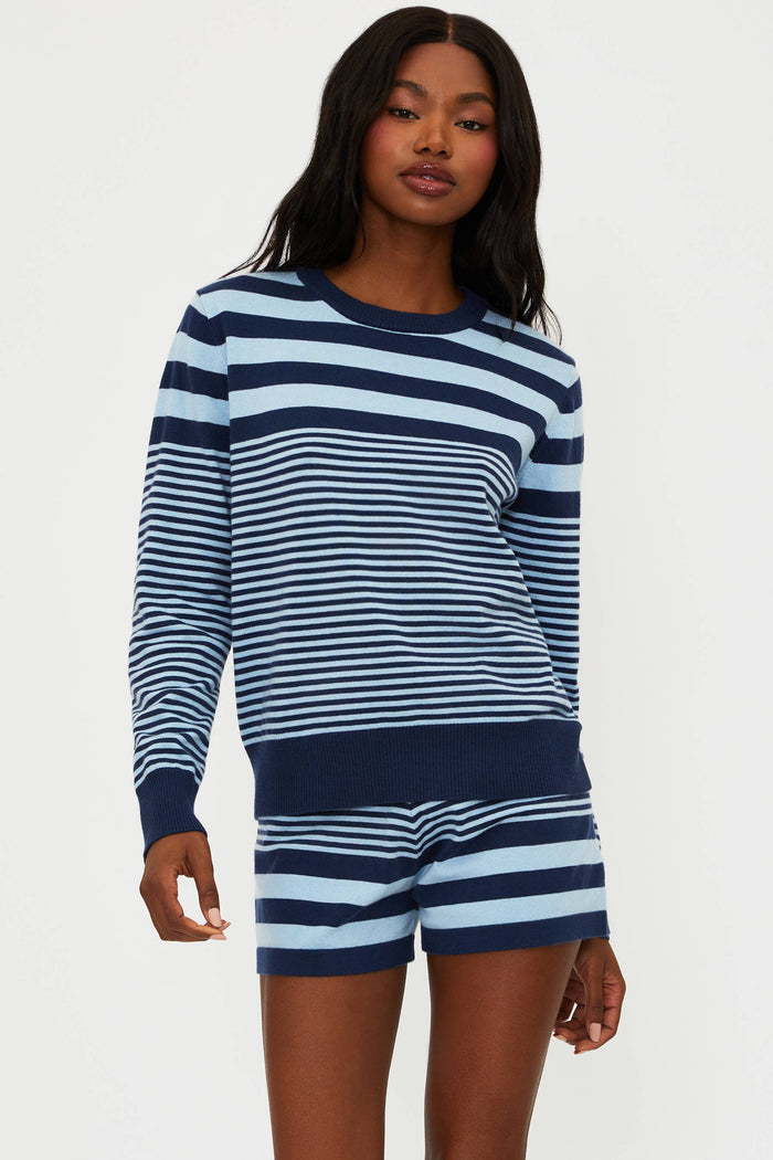 Woman wearing a navy and white striped long-sleeve top and shorts on a white background